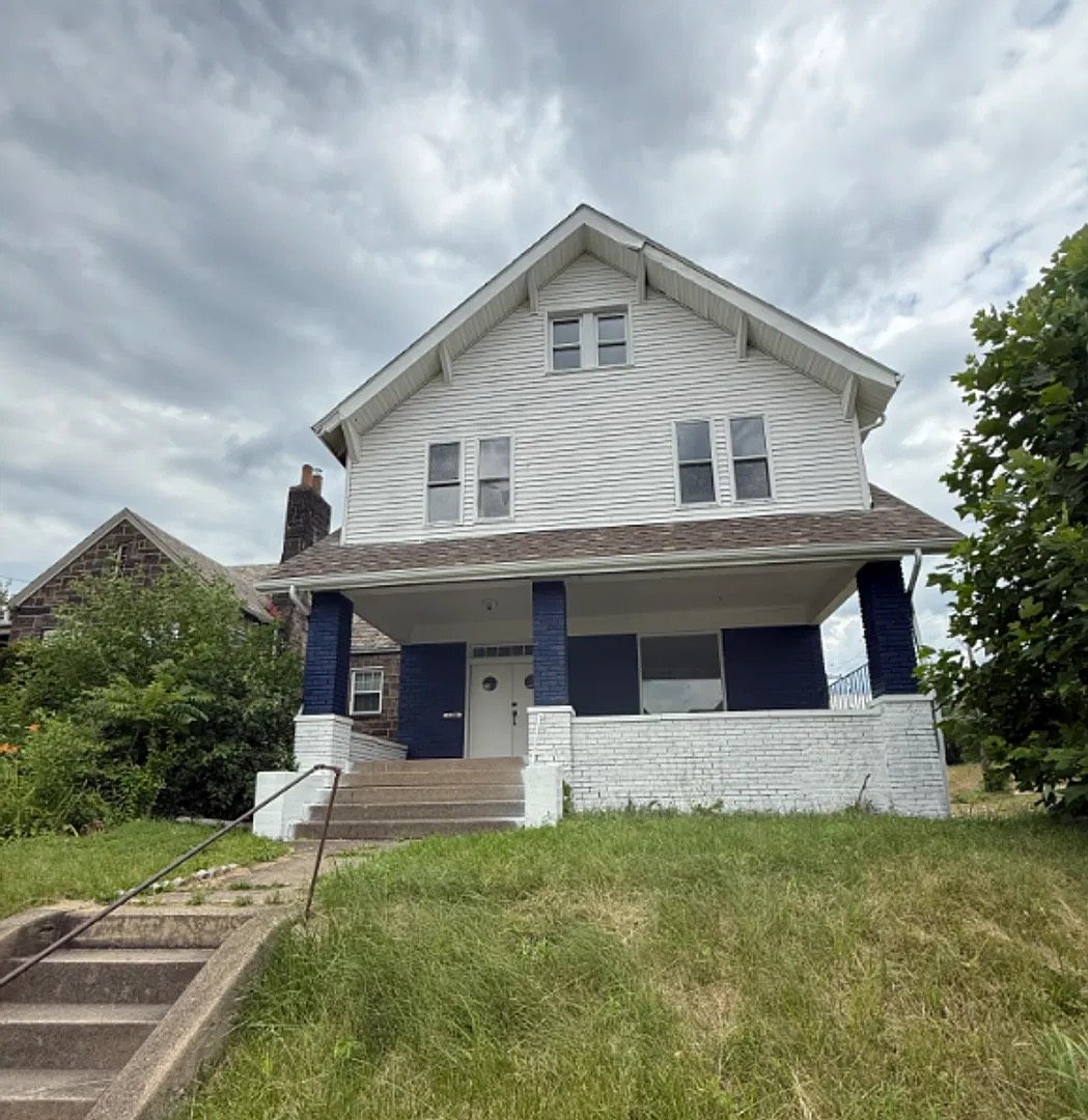 White two-story house with a navy porch at 1100 Kenneth Avenue